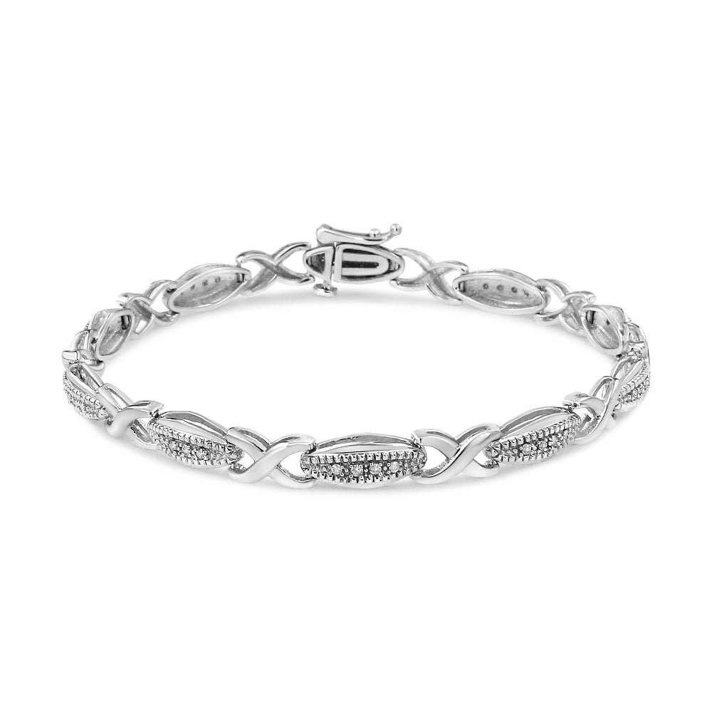 White metal bracelet with linked oval and X-shaped segments, some adorned with small white round gemstones in prong settings, shown from a front angle.