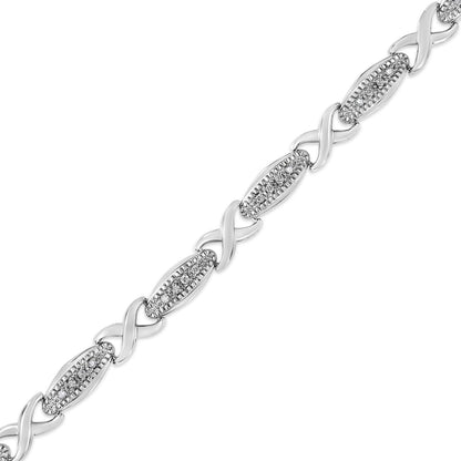 Diagonal close-up of a white metal bracelet with alternating twisted links and oval sections set with round white gemstones in prong settings.