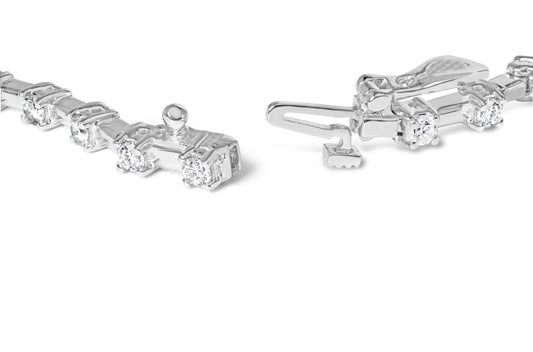 Close-up view of white metal bracelet with round white gemstones in prong settings and an open clasp, angled from above.