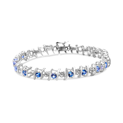 White metal bracelet with alternating round blue and white gemstones in prong settings, shown from a slightly elevated front angle.