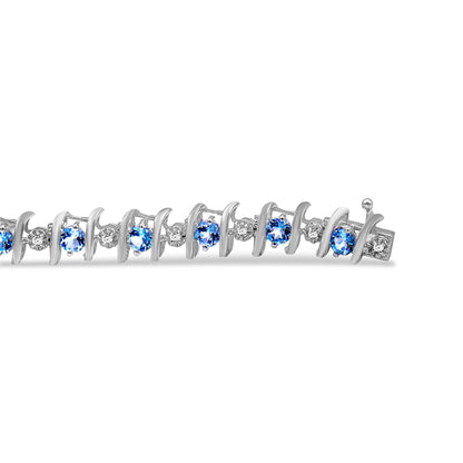 Close-up side angle of a white metal bracelet with alternating round blue and white gemstones in prong settings.