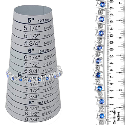 White metal bracelet with alternating round blue and white gemstones in prong settings, shown on a ring sizing cone and next to a ruler for size reference, front and side views.