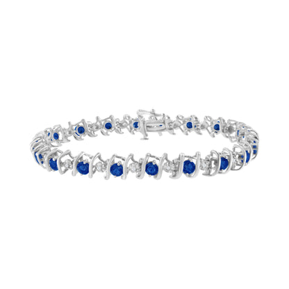 White metal bracelet with alternating round blue and white gemstones in a prong and miracle setting, shown at a slight side angle.