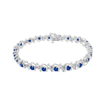 White metal bracelet with alternating round blue and white gemstones in prong and miracle settings, shown in a front-facing angle.