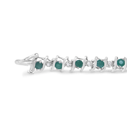 Close-up side angle of a white metal bracelet with alternating round green and white gemstones in prong settings.