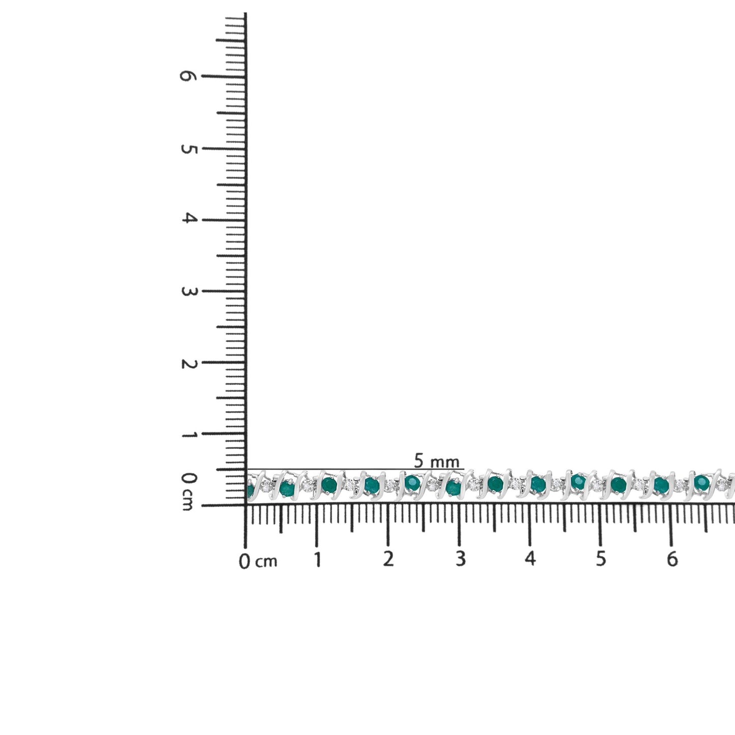 White metal bracelet with alternating round green and white gemstones in prong settings, laid flat on a ruler for size reference, top-down angle.