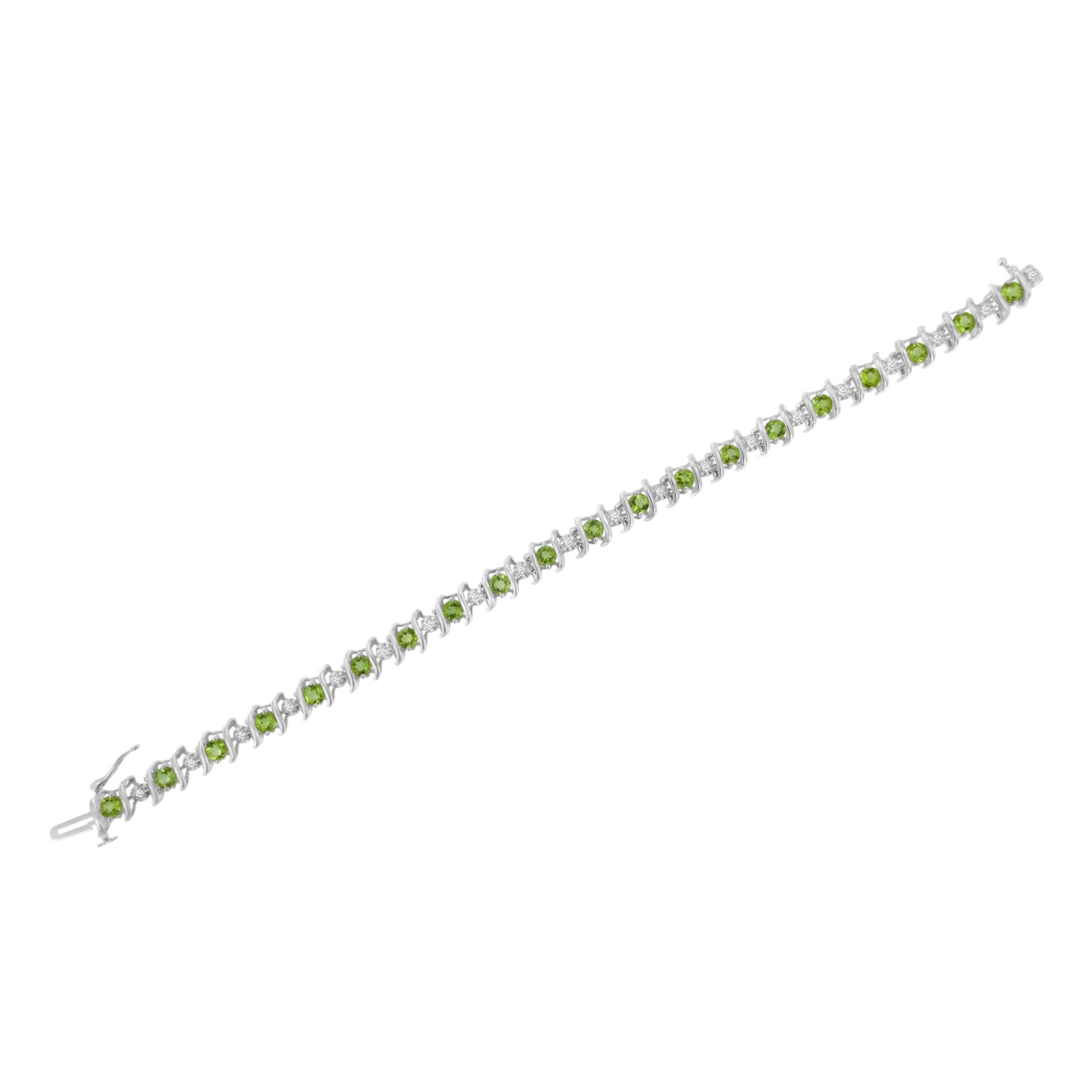 White metal bracelet with alternating round white gemstones in miracle setting and round green gemstones in prong setting, shown in a flat lay angled view.