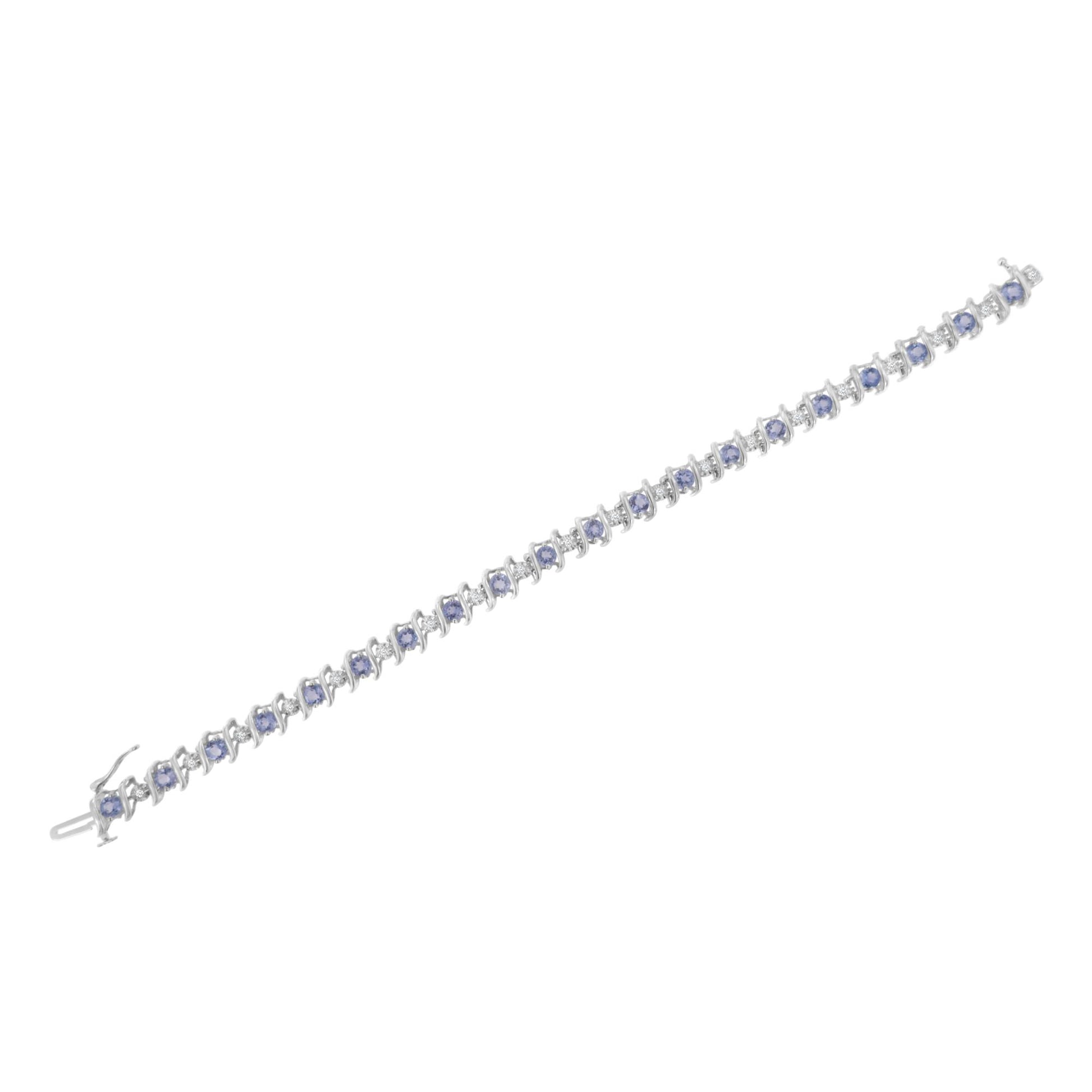 White metal bracelet with alternating round blue gemstones in prong settings and round white gemstones in miracle settings, shown in a top-down angle.