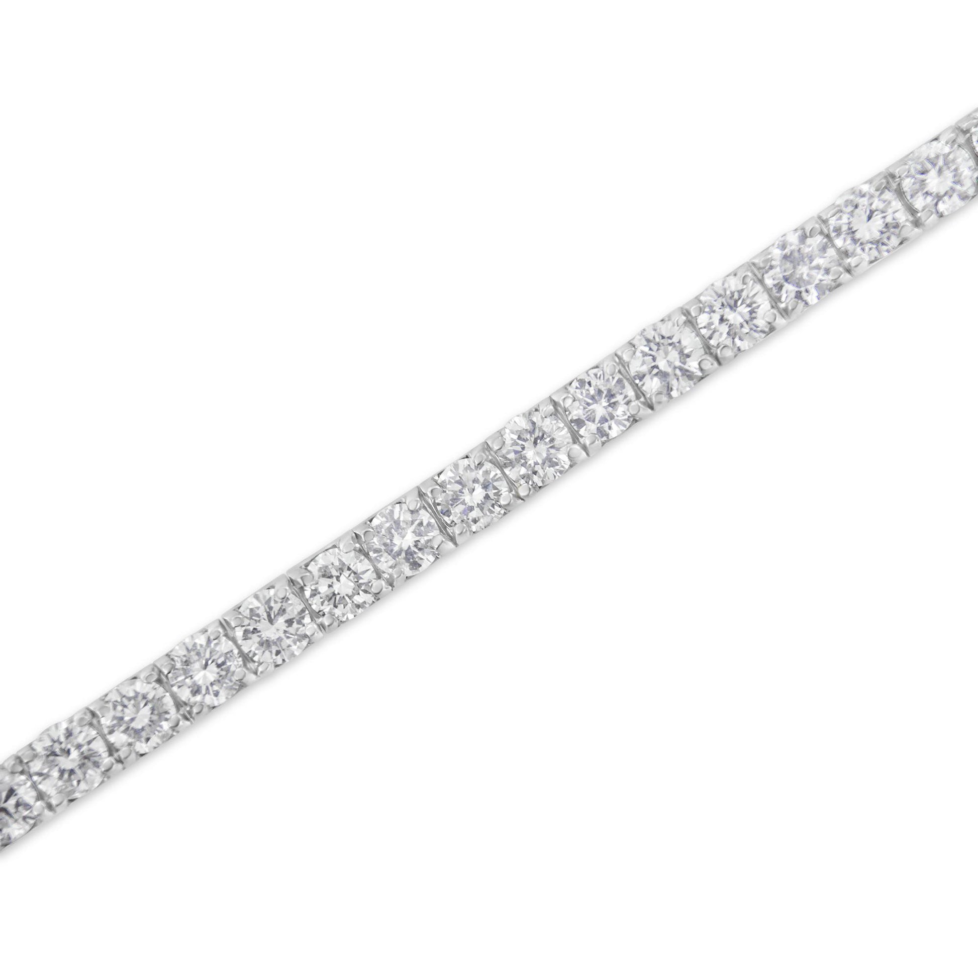 Close-up angled view of a white metal bracelet featuring a row of round white gemstones in prong settings.