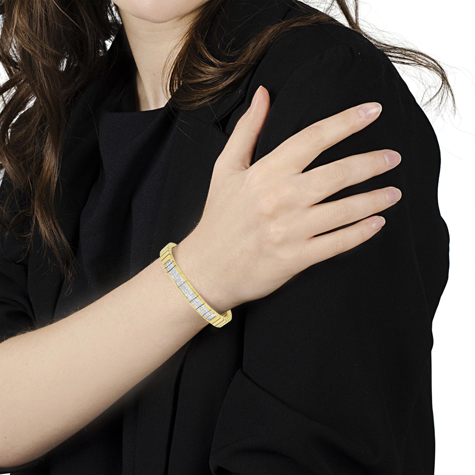 Yellow bracelet with white princess-shaped gemstones in invisible setting worn on model's wrist, angled front view.