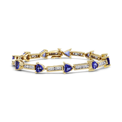 Yellow bracelet with alternating blue trillion-shaped gemstones in prong settings and rectangular sections with channel-set round white gemstones, shown in a front angle view.