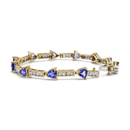 Yellow metal bracelet with alternating blue trillion-shaped gemstones in prong settings and rectangular sections with channel-set white round gemstones, shown from a front angled view.
