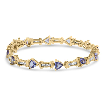 Yellow bracelet viewed from a slight angle featuring alternating blue trillion-shaped gemstones in prong settings and white round gemstones in channel settings.