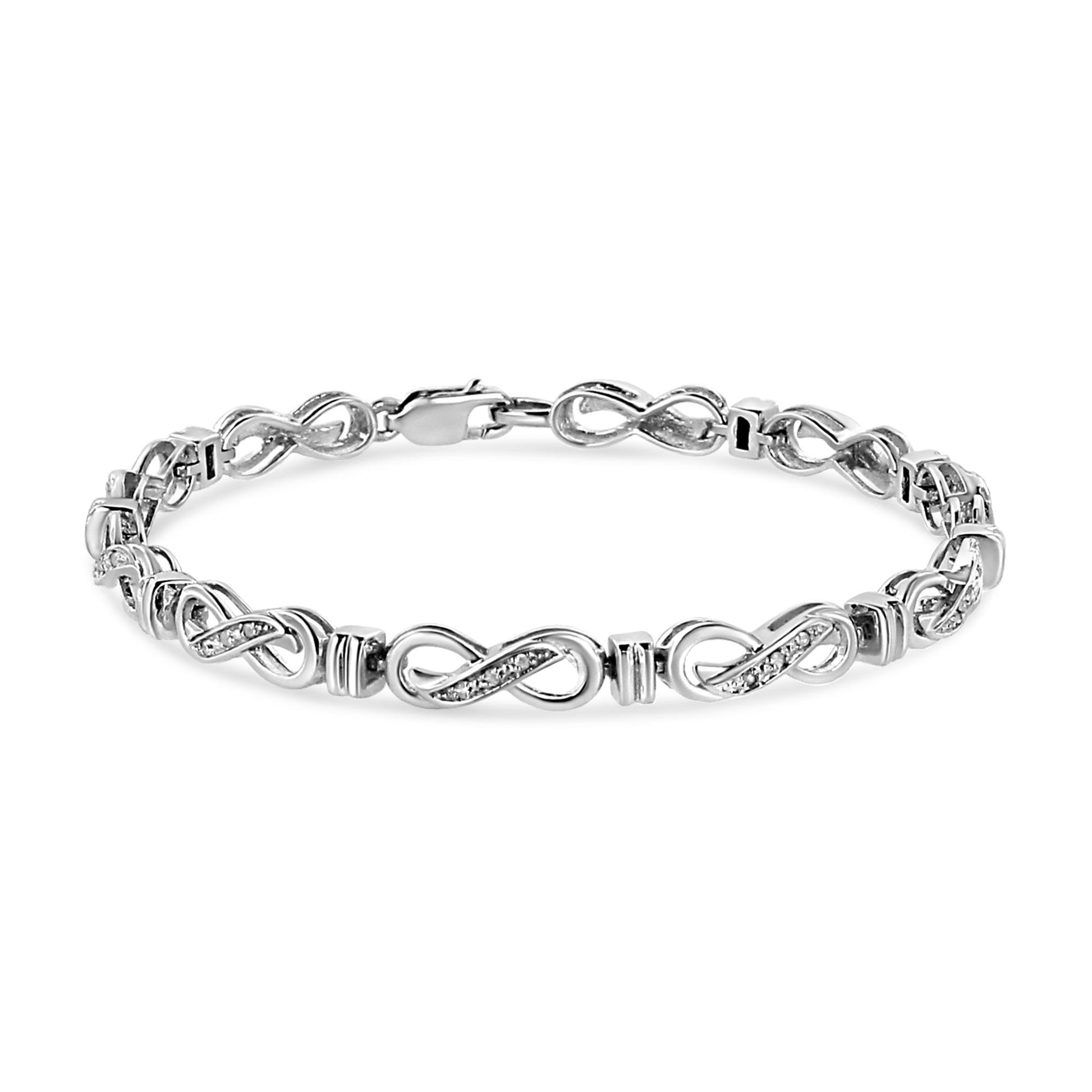 White metal bracelet with infinity-shaped links accented with small white gemstones, shown from a front angle.