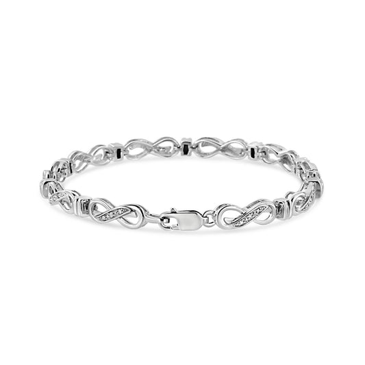 White bracelet with infinity-shaped links inlaid with round white gemstones in prong settings, shown from a front angle.