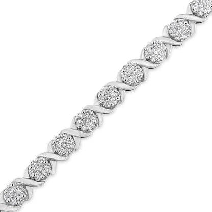 Diagonal close-up of a white metal bracelet featuring clusters of round white gemstones in prong settings alternating with curved metal links.
