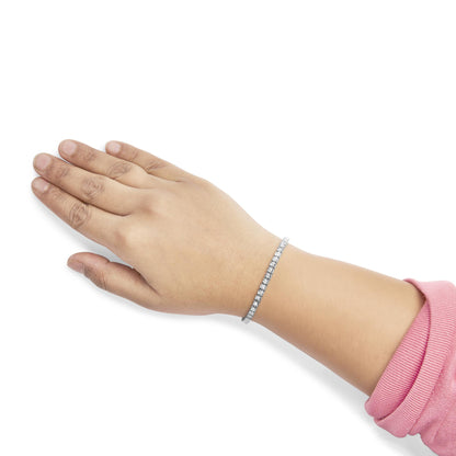 White metal bracelet with round white gemstones in miracle setting, shown on a model's wrist from a side angle.