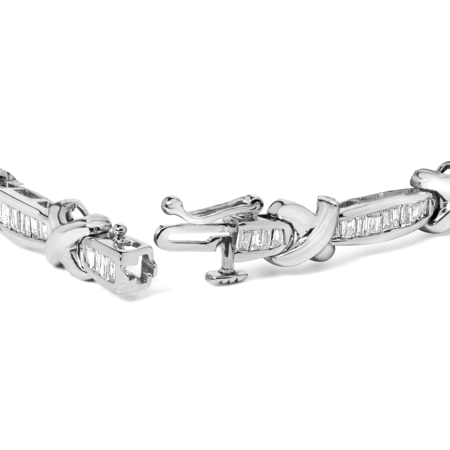 Close-up angle of a white metal bracelet with baguette-shaped white gemstones in a channel setting and a detailed clasp.