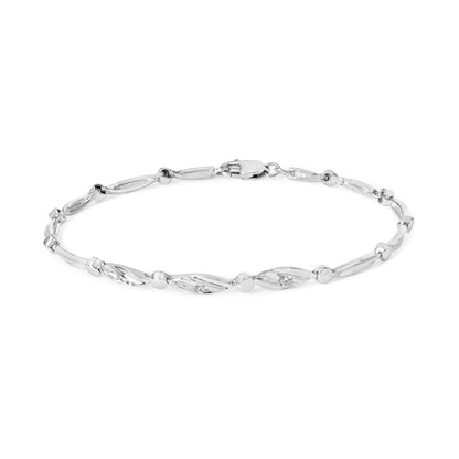 White metal bracelet with elongated oval links featuring round white gemstones in channel settings, shown in a flat top-down view.
