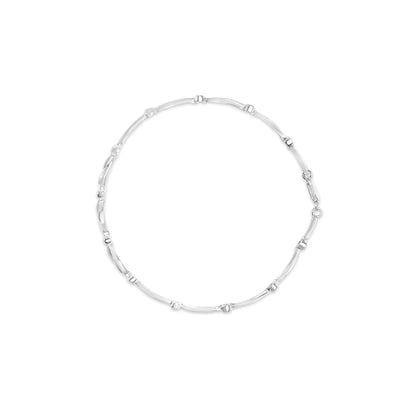 Top-down view of a white metal bracelet with round white gemstones set in a channel setting along the links.