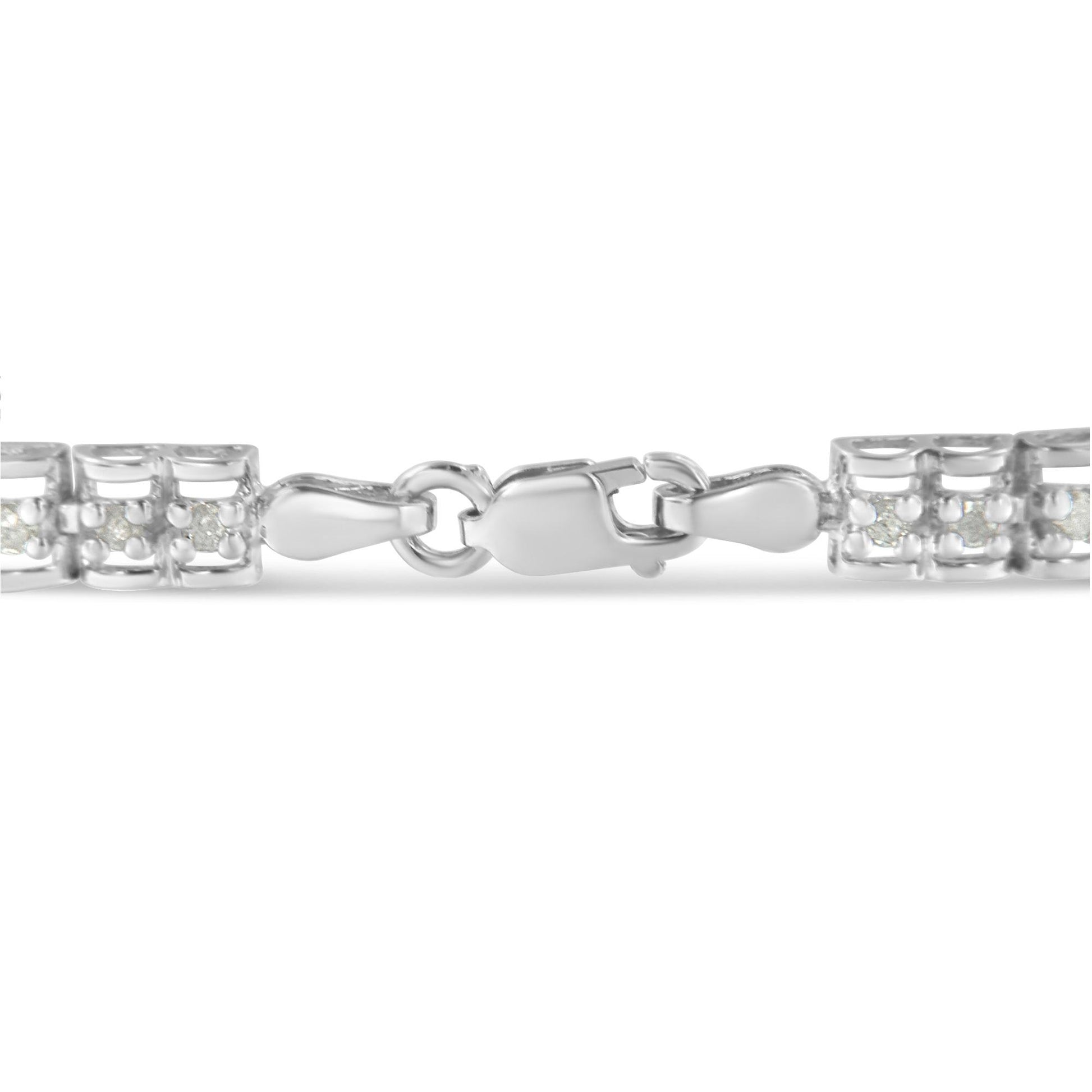 Close-up front angle of a white bracelet clasp with round white gemstones in prong settings on either side.