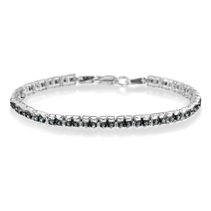 White metal bracelet with prong-set round blue gemstones, shown in a front angled view.