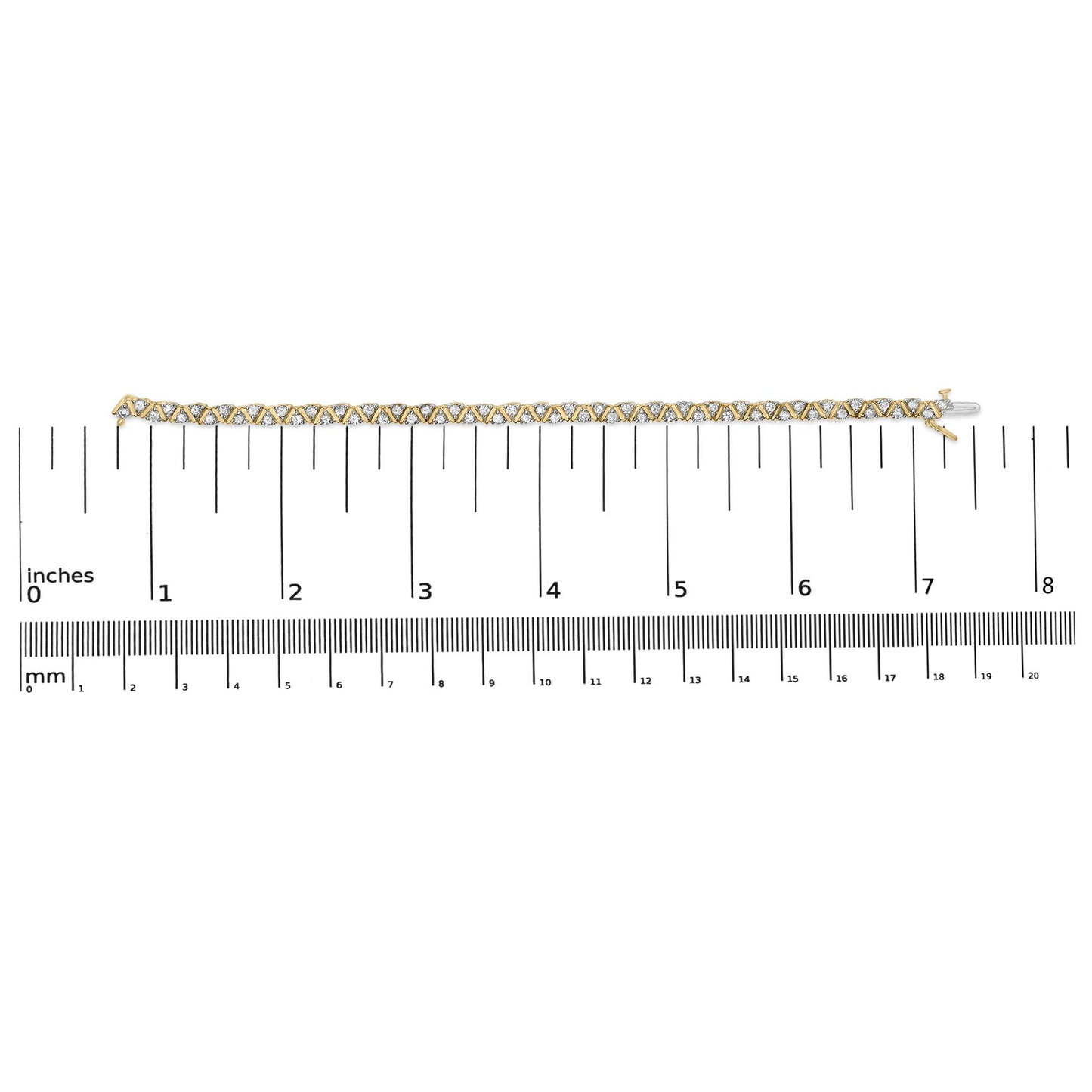 Yellow metal bracelet with round white gemstones in three-prong settings placed in a zigzag pattern, displayed flat on a ruler for size reference, shot from above.