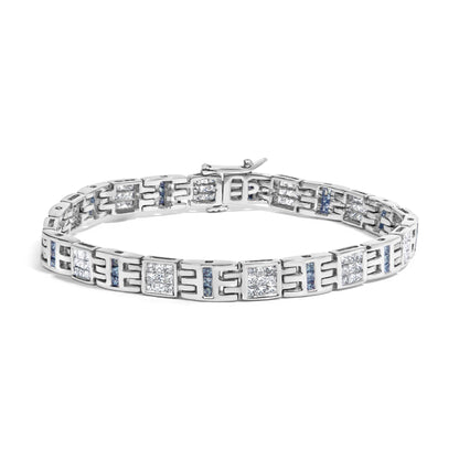 White metal bracelet with alternating square clusters of white gemstones in invisible setting and vertical rows of blue gemstones in channel setting, shown from a front angled view.