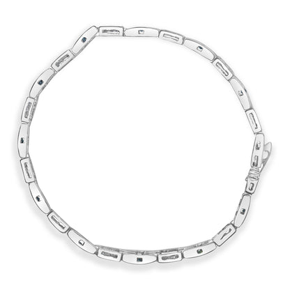 Top-down view of a white metal bracelet with rectangular links featuring princess-shaped white gemstones in invisible settings and blue gemstones in channel settings.