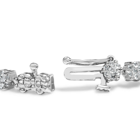 Close-up front angle of a white metal bracelet clasp with round white gemstones in prong settings.