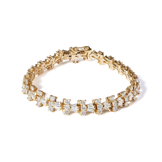 Yellow metal bracelet with alternating round and baguette white gemstones, shown from a front angle.