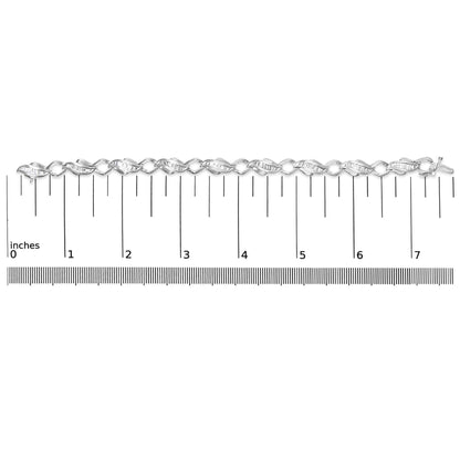 White metal bracelet with alternating twisted links set with white baguette-shaped gemstones in a channel setting, shown lying flat on a ruler scale, top-down angle.