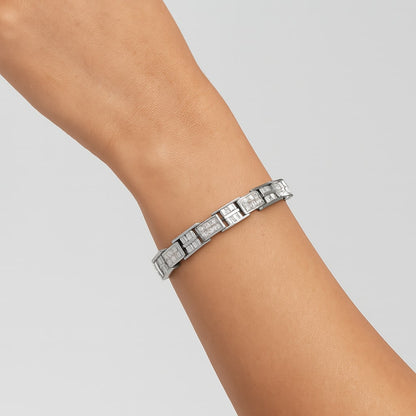 White bracelet with alternating sections of baguette and princess-shaped white gemstones, shown worn on wrist of model at an angle.