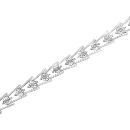 Diagonal close-up of a white metal bracelet featuring round white gemstones set in a miracle setting.