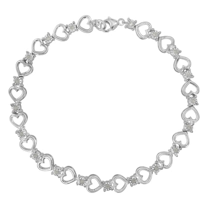 Top-down view of a white metal heart link bracelet with round white gemstones set between each heart, featuring a clasp closure.