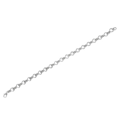 White metal bracelet with linked open heart shapes and round white gemstones in a miracle setting, photographed from a top angle.