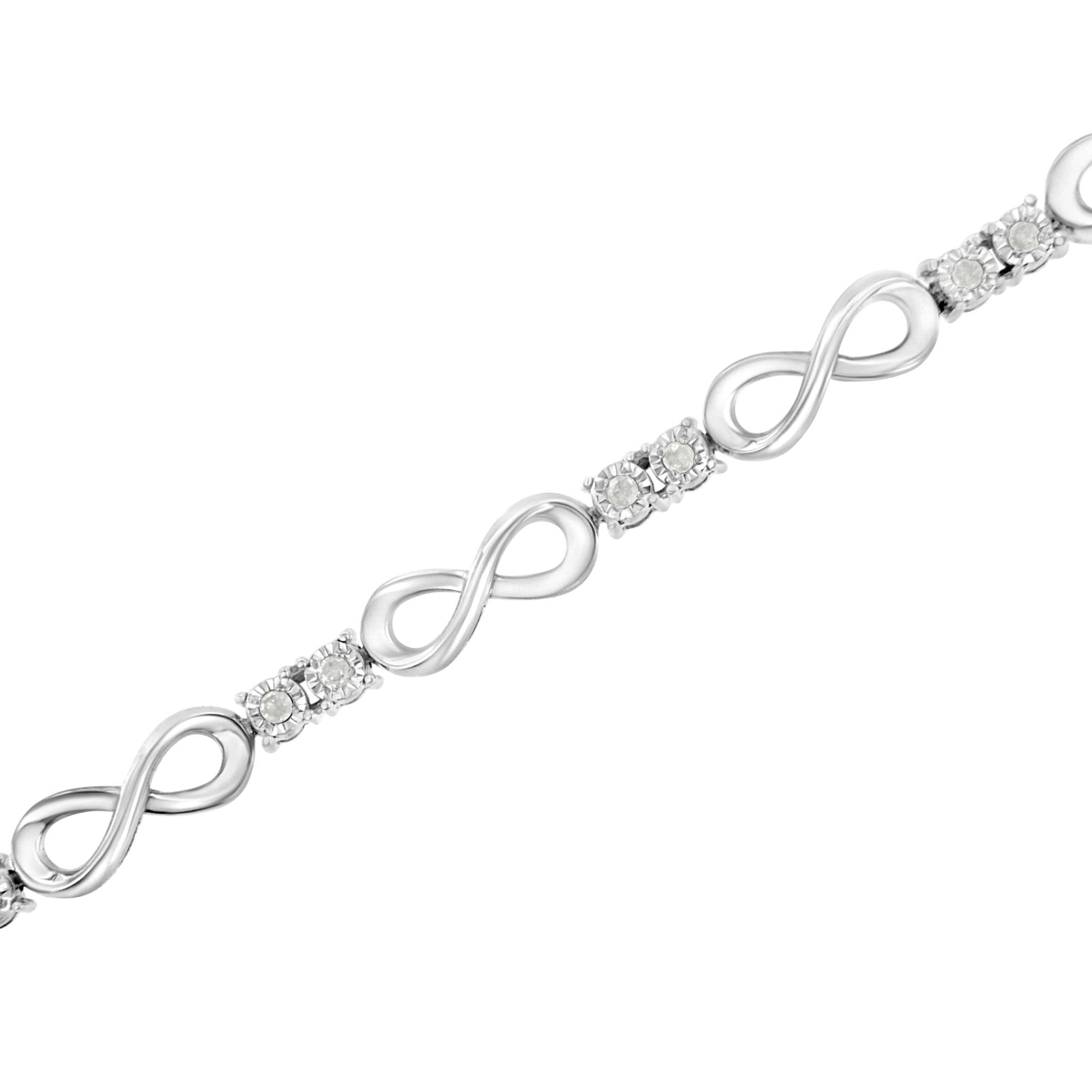 White metal bracelet with alternating infinity-shaped links and clusters of round white gemstones set in a Miracle setting, shown in a diagonal close-up angle.