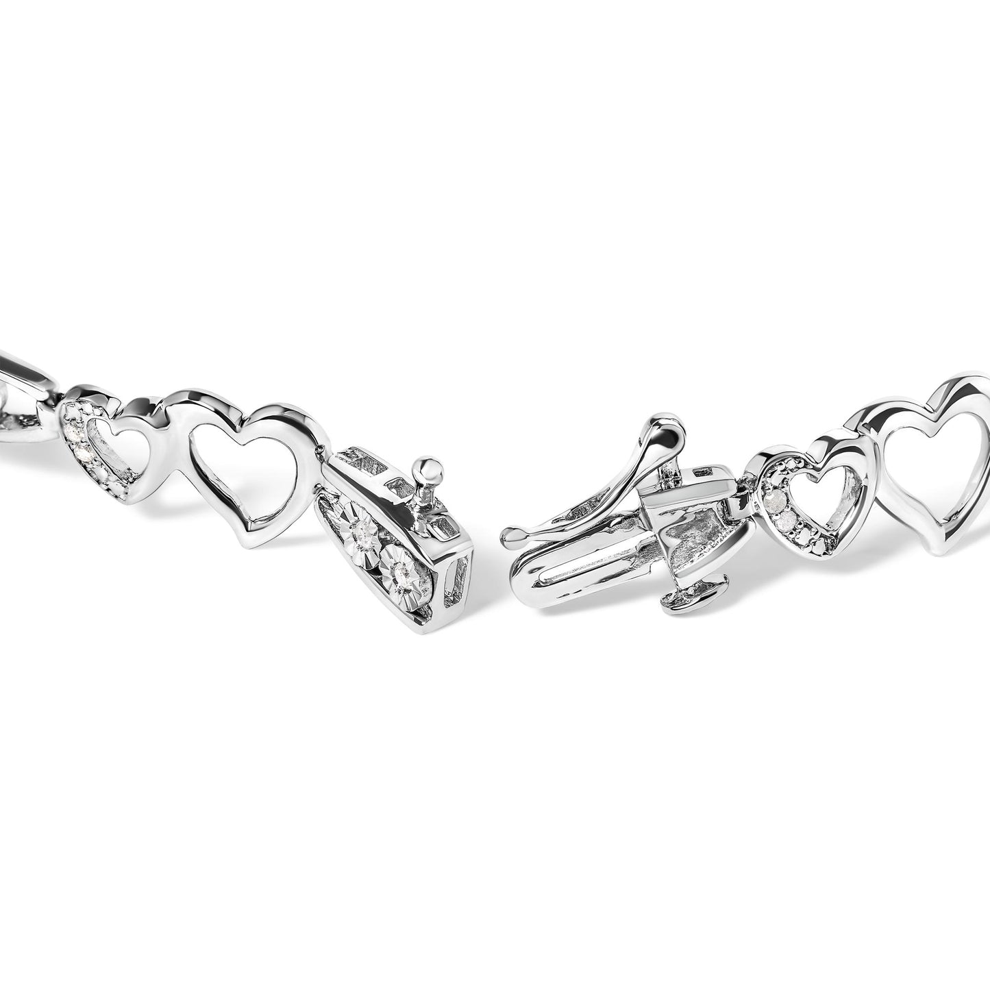 Close-up of a white metal bracelet featuring open heart-shaped links, some accented with small white gemstones, shown from an angle highlighting the clasp mechanism.