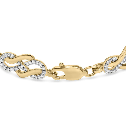 Close-up front angle of a yellow metal bracelet featuring interlocking links, some set with small round white gemstones in a pave setting, with a lobster clasp.