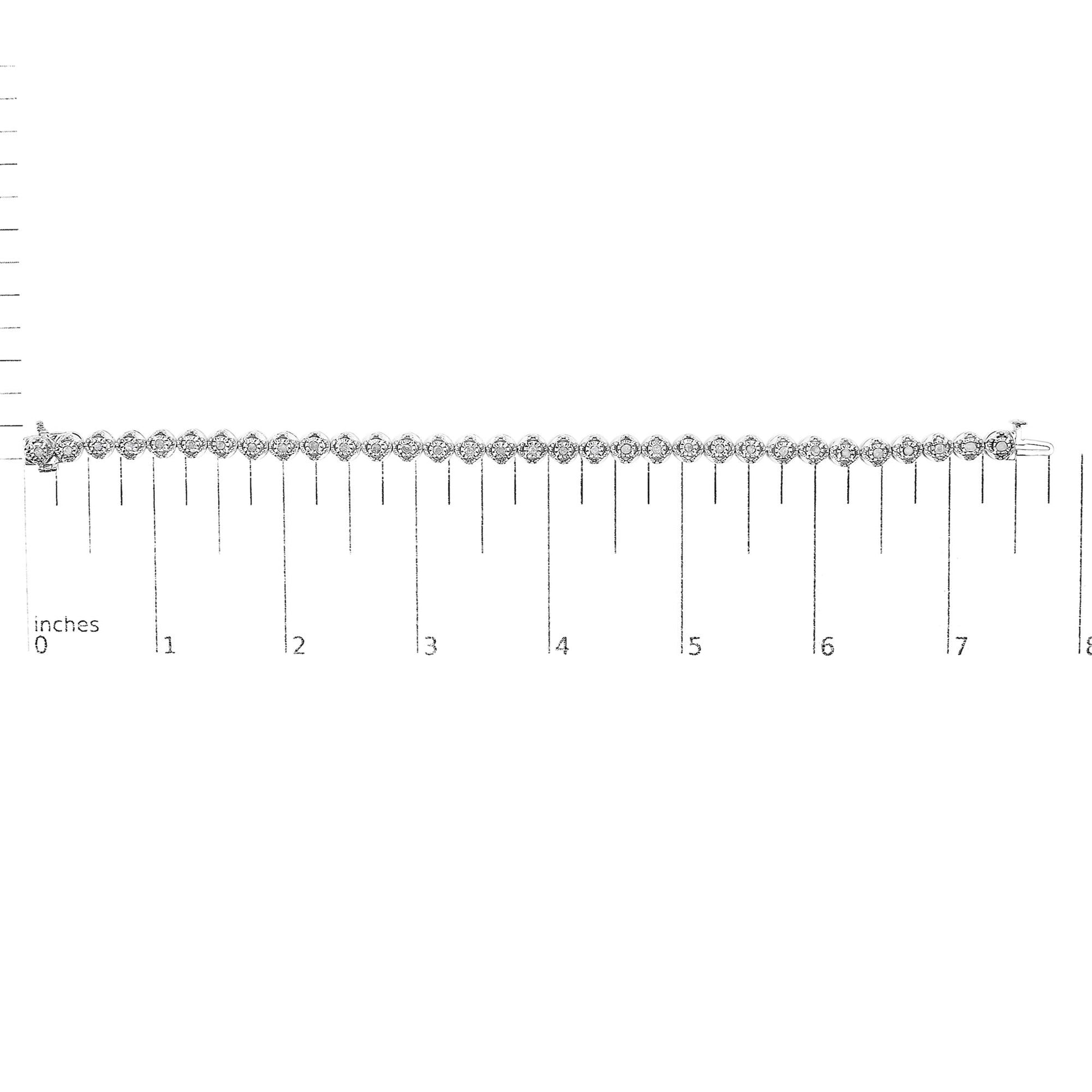 White metal bracelet with round white gemstones in prong settings, laid flat on a ruler for size reference, viewed from above.