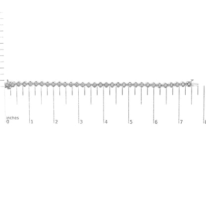 White metal bracelet with round white gemstones in prong settings, laid flat on a ruler for size reference, viewed from above.