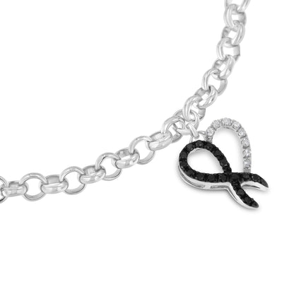 Close-up front angle of a white metal bracelet with a chain link design and a loop-shaped charm adorned with round white and black gemstones in prong settings.