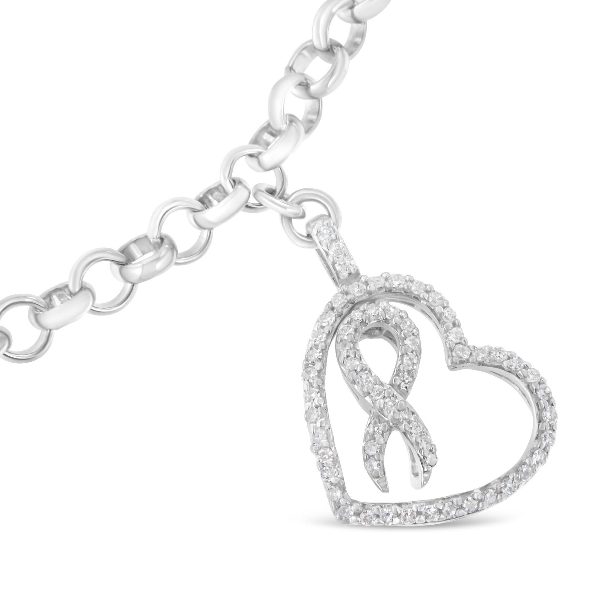 Close-up angled view of a white metal bracelet featuring a heart-shaped charm outlined with white round gemstones in prong settings and a ribbon-shaped design inside the heart also adorned with white round gemstones.