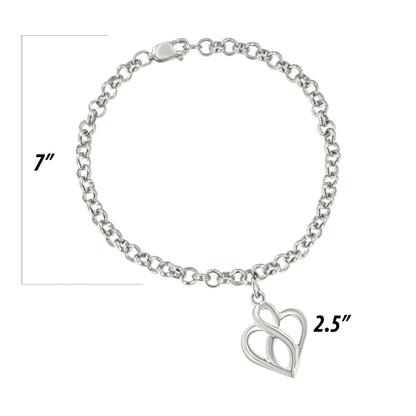 Top-down view of a white metal chain bracelet with a heart-shaped charm, displayed on a ruler for size reference.