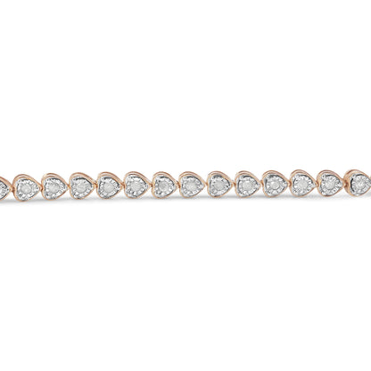 Close-up front view of a rose-colored bracelet featuring a continuous line of heart-shaped settings, each with a round white gemstone in a miracle setting.