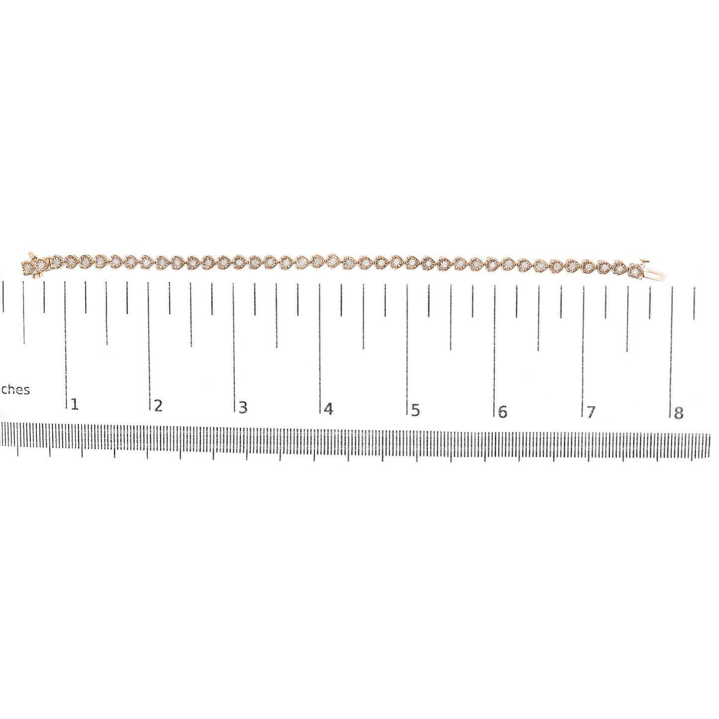 Rose-colored bracelet with round white gemstones in miracle setting, laid flat on a ruler for size reference, top-down view.