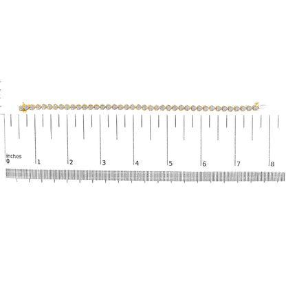 Yellow metal bracelet with round white gemstones in miracle setting, displayed horizontally on a ruler for size reference, front facing shot.