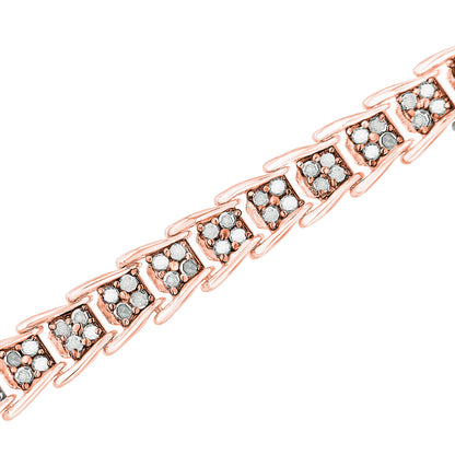 Close-up diagonal shot of a rose-colored bracelet with sections each set with multiple round white gemstones in prong settings.