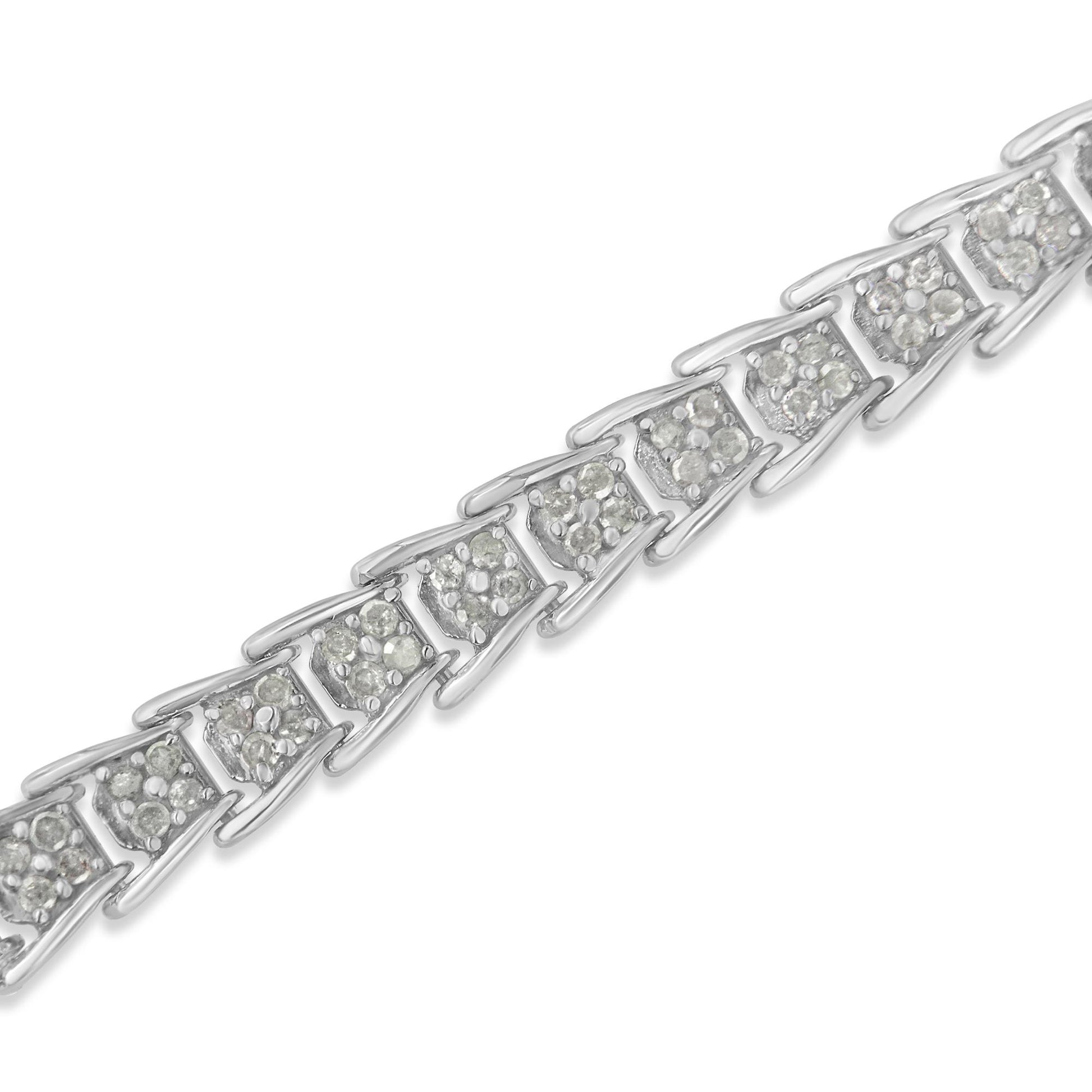 Diagonal close-up of a white bracelet with triangular links, each set with multiple round white gemstones in prong settings.