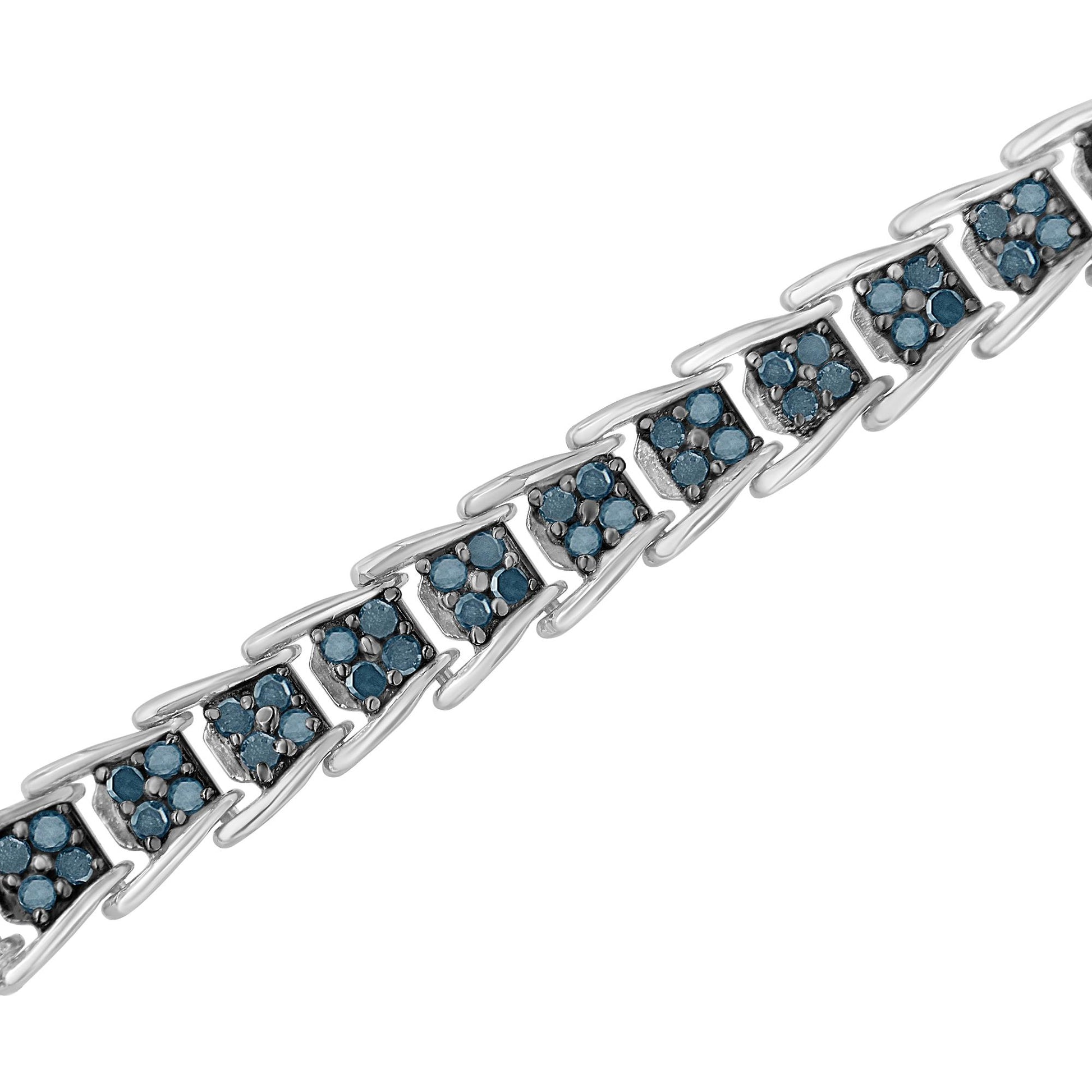Diagonal close-up of a white metal bracelet featuring linked triangular segments, each set with multiple round blue gemstones in prong settings.